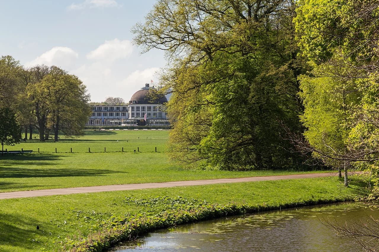 Meadows and trees in Bürgerpark with the Park Hotel in the distance.